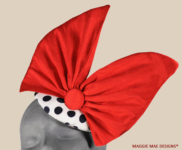 Ariel red pink polka dot button fascinator trimmed with freeform red silk bow.