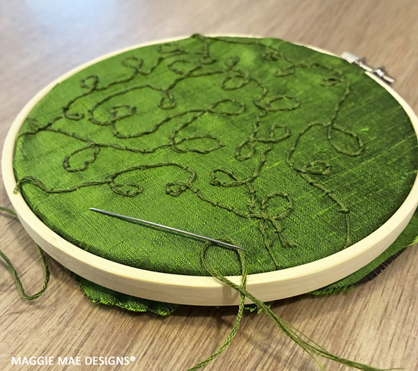 Swirling cranberry vines created with embroidery thread and milliner Sally Faith Steinmann's imagination!